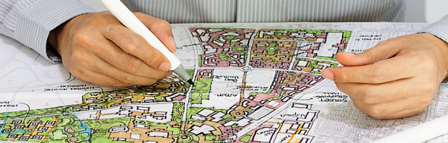 main d'un urbanisme qui dessine sur une carte de site