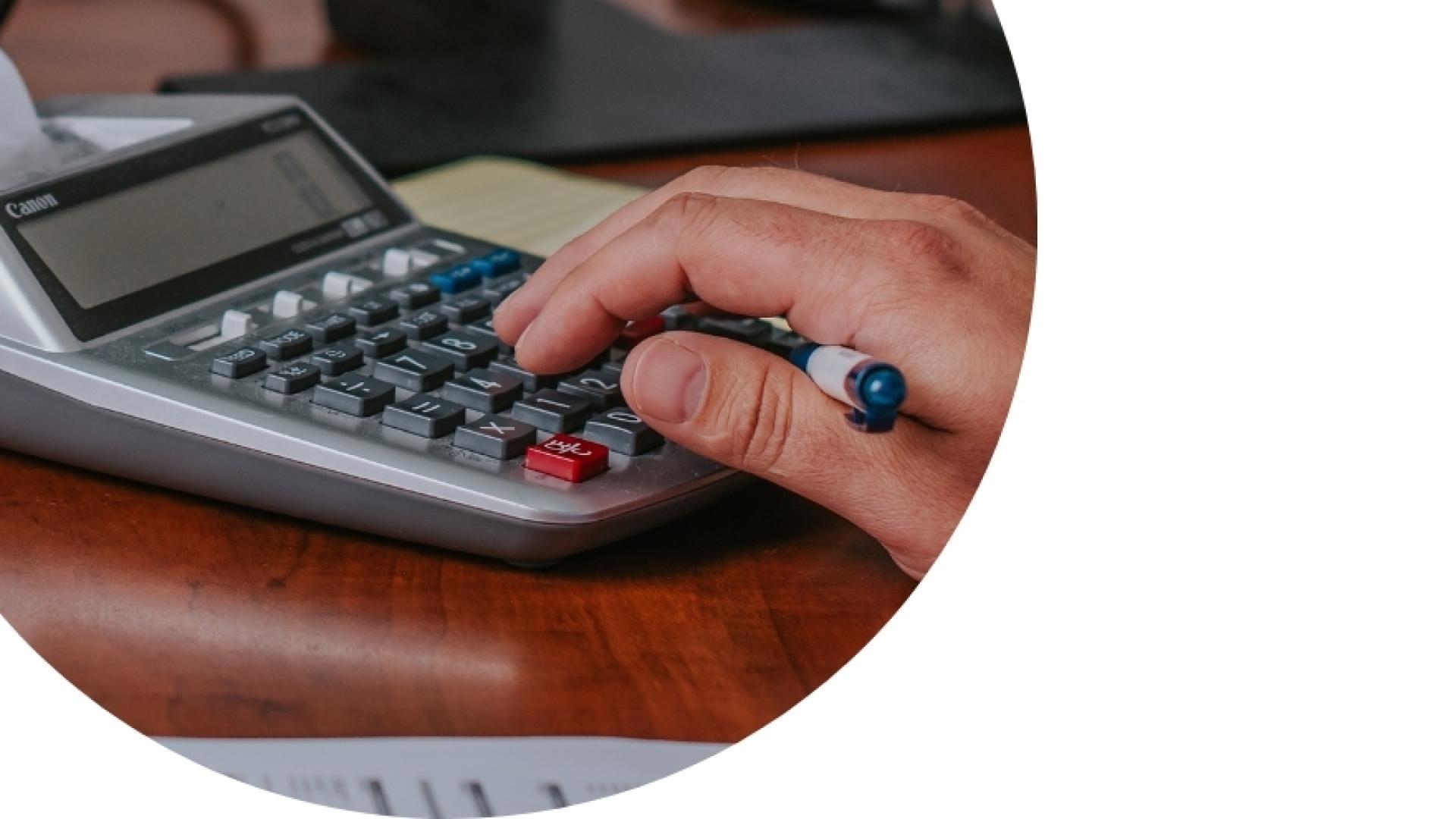 hand typing on a calculator on a office desk