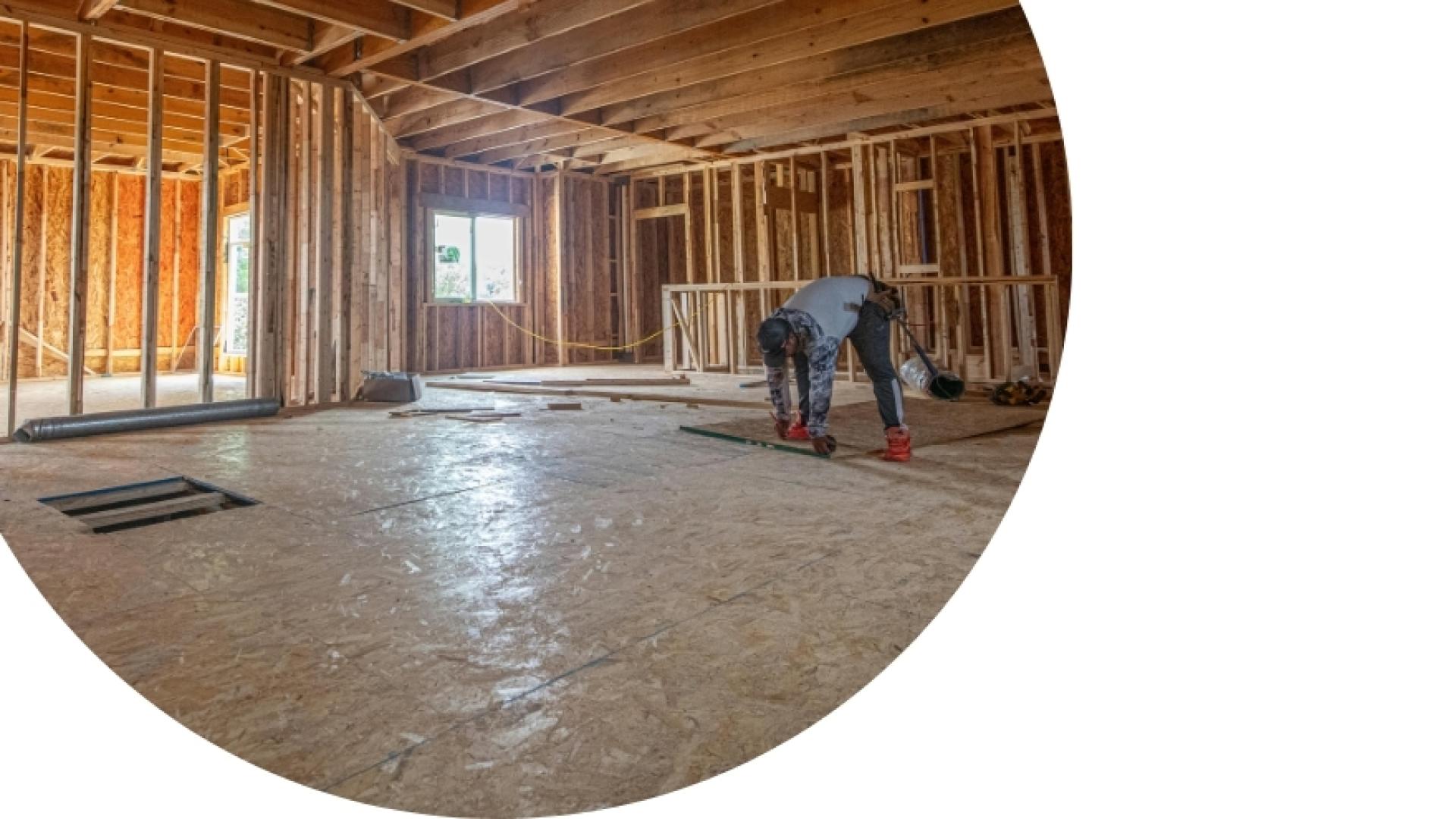 a construction worker working in a house under construction just framed