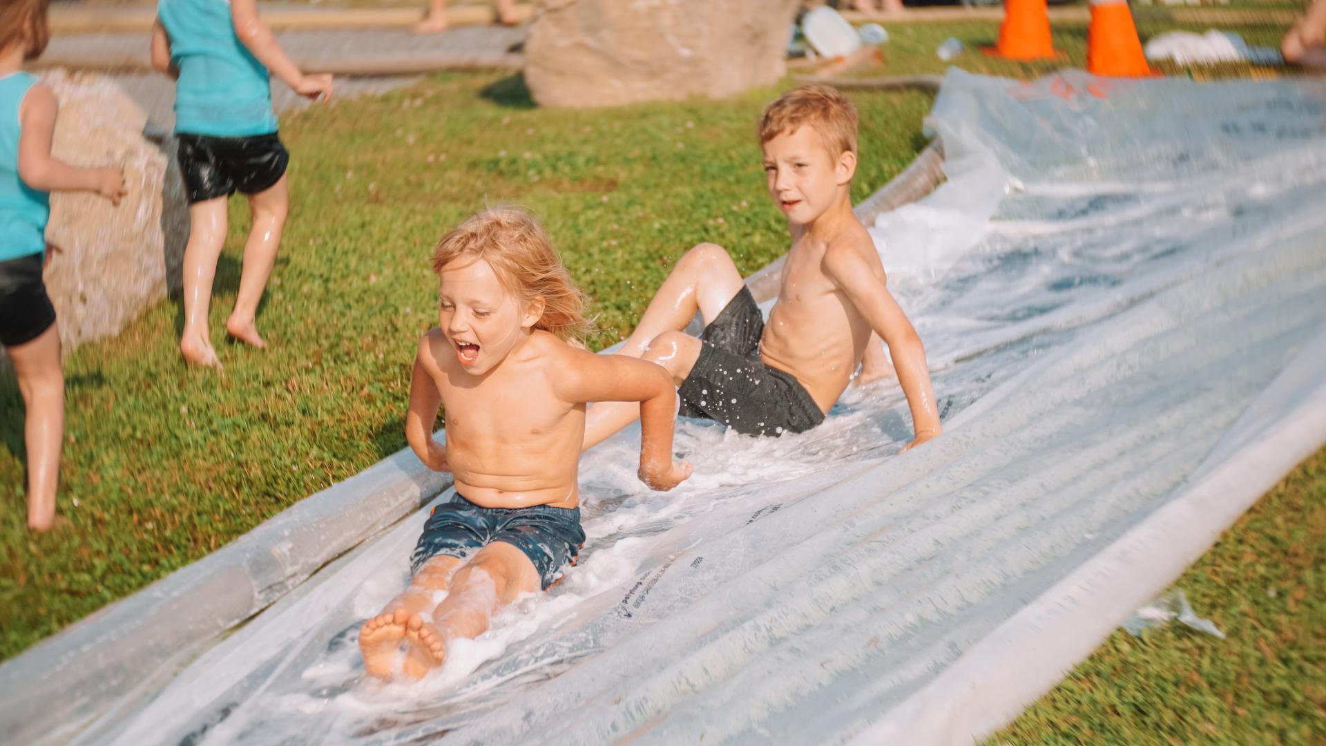 Child sliding down a water slide activity during daytime Canada Day festivities at L’Orignal Beach.