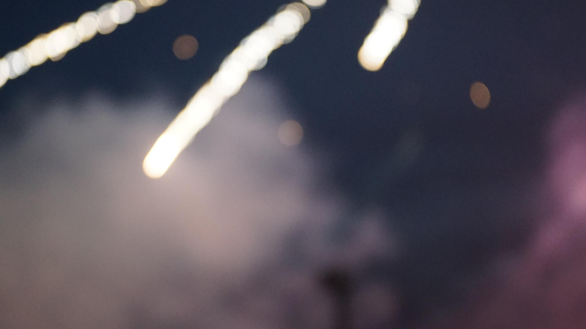 Person recording fireworks on a phone during the Canada Day fireworks show at L’Orignal Beach.