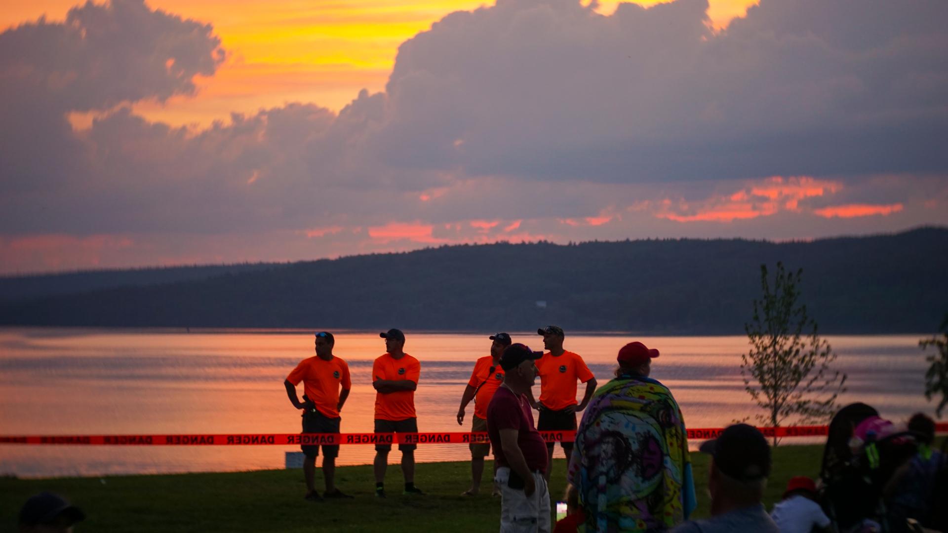 People gathered near the waterfront at sunset during Canada Day celebrations at L’Orignal Beach.