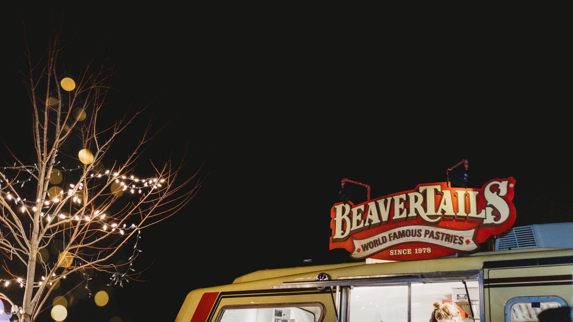 A BeaverTails food truck serving visitors during the Christmas parade festivities at night.