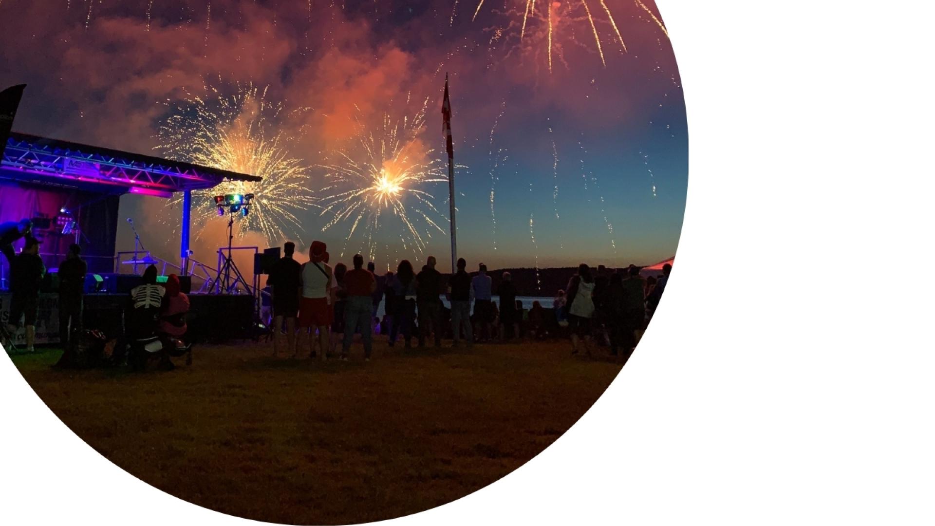 fireworks show on the beach at night, during an event with the stage lighted up