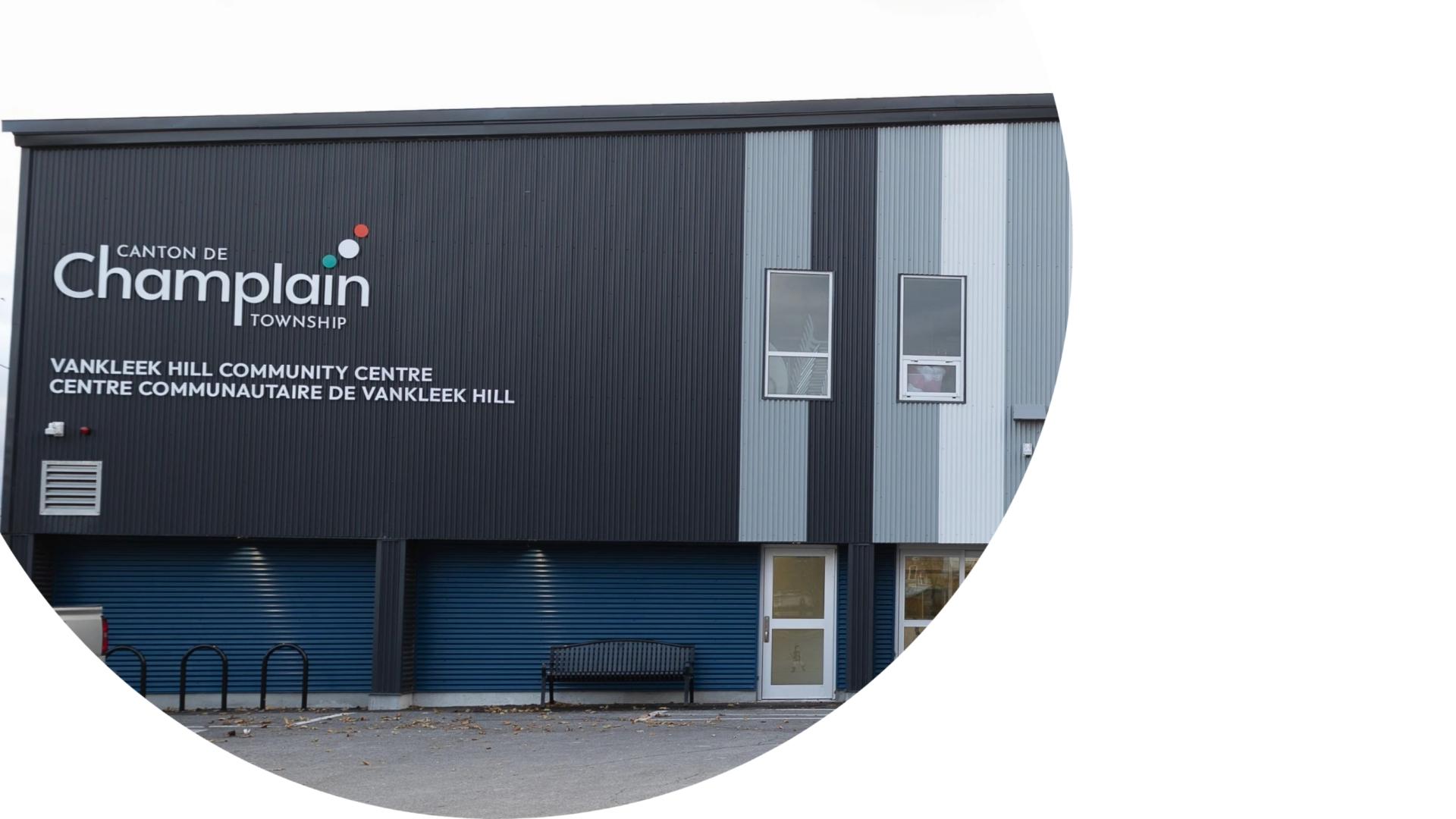 Exterior view of the Vankleek Hill Arena featuring modern blue and grey metal siding and Champlain Township branding near the main entrance.