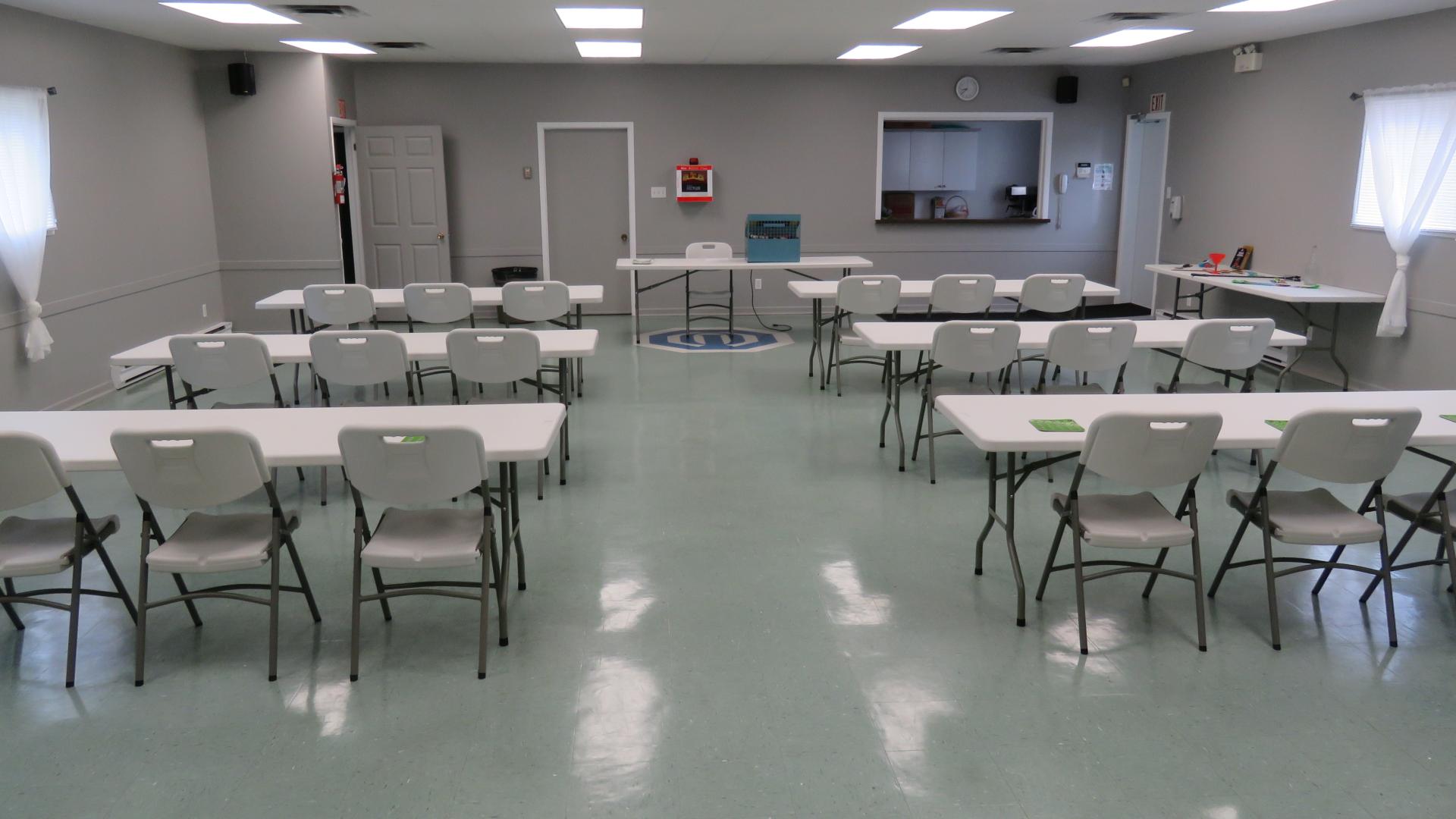 Community hall set up with tables and chairs for a meeting, training session, workshop, or community event.