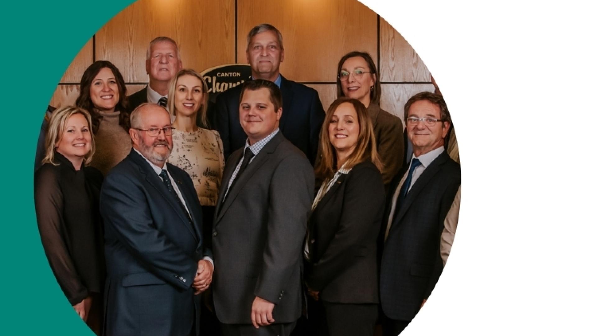 Professional group portrait of ten team members posing together.