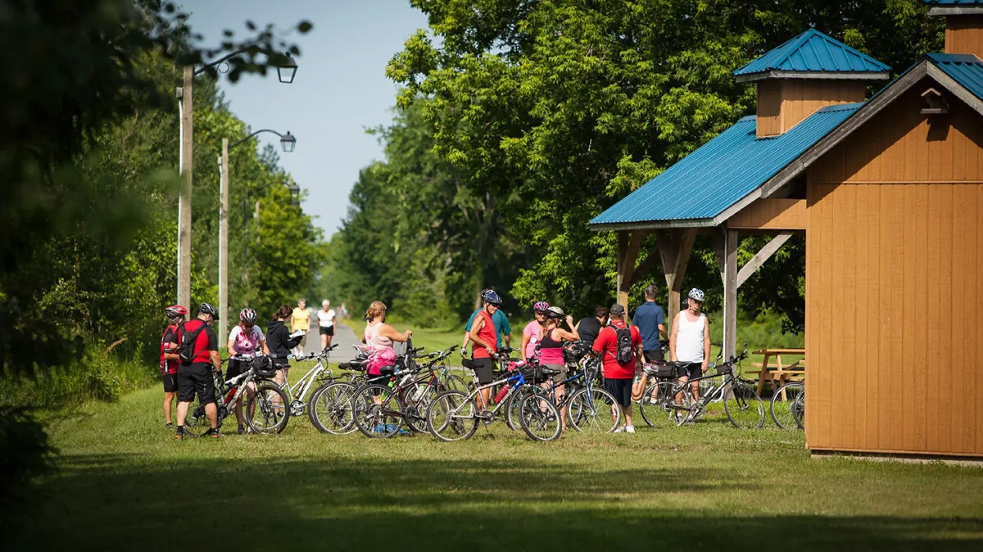 Cyclists gathered at a trailhead pavilion along the Prescott and Russell Recreational Trail, preparing for a group ride.