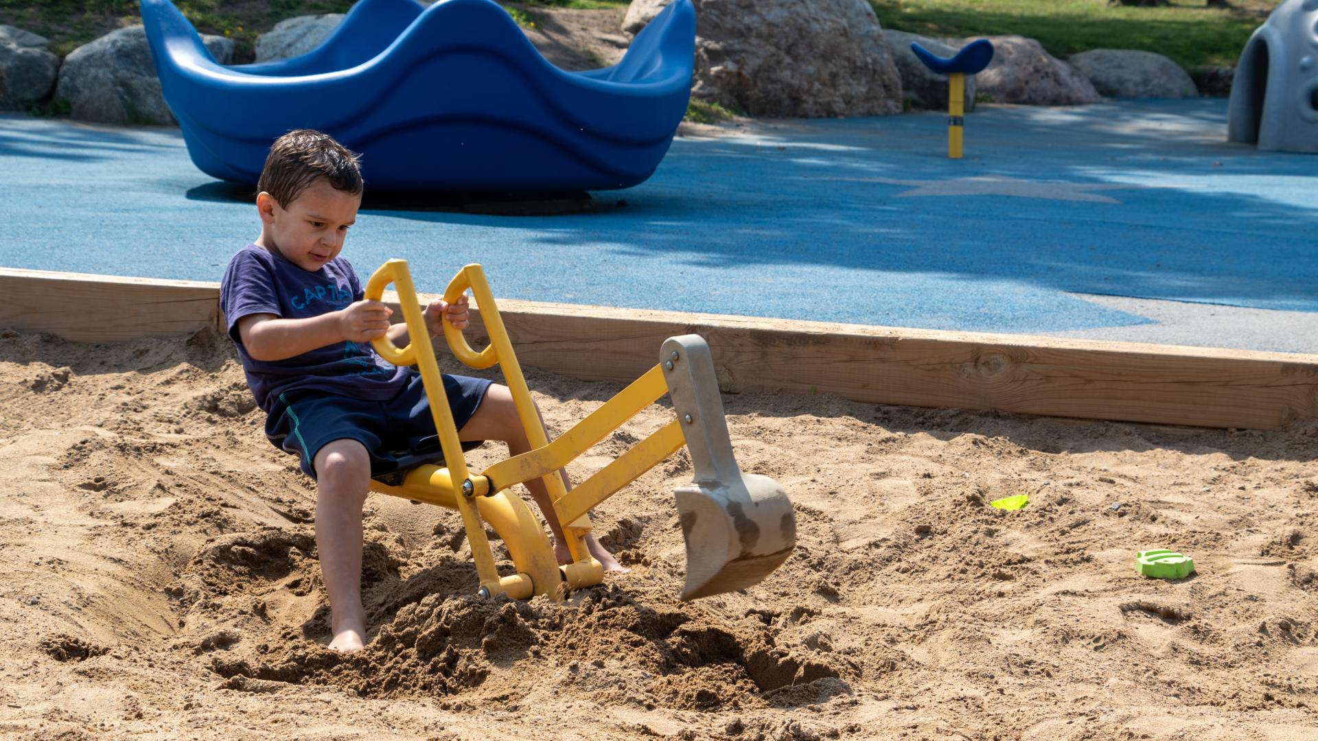little boy playing in the sand