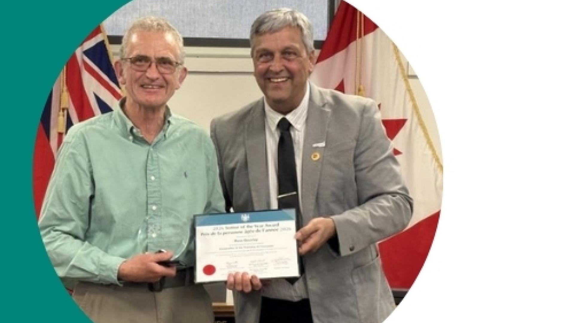 a men receiving an award from the Mayor Normand Riopel