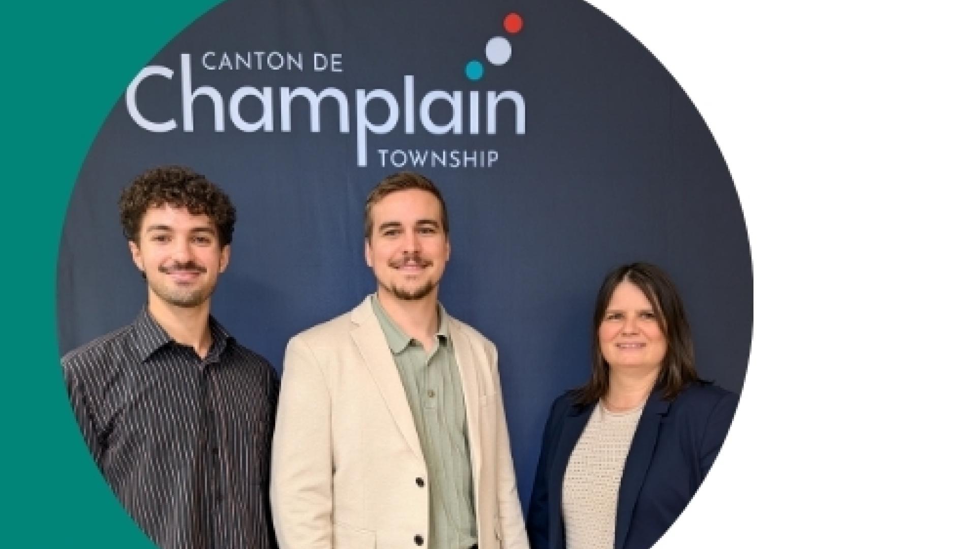 Three new employees standing in front of a black backdrop