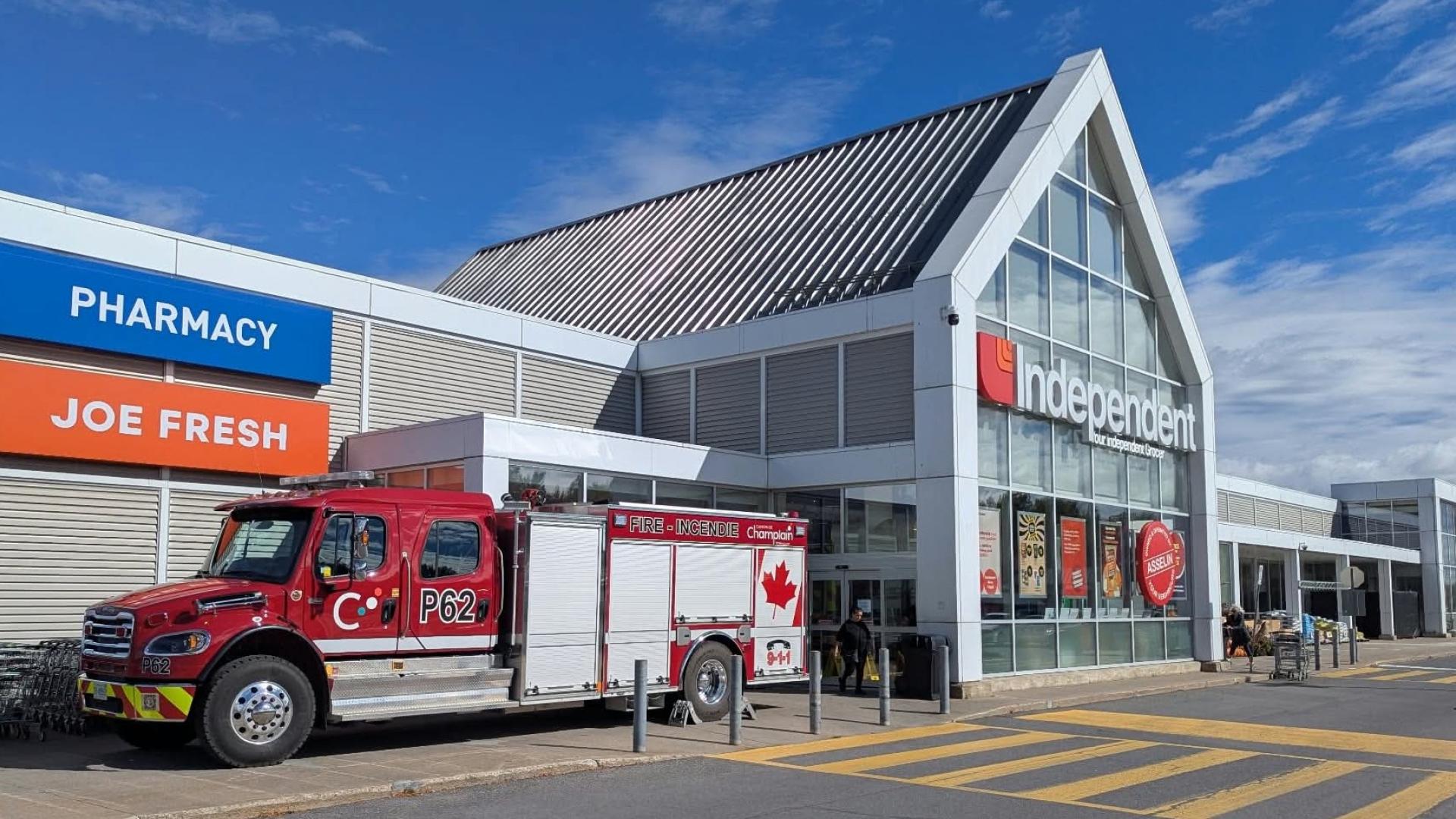 A red fire truck parked in front of Your’s Independent Grocer