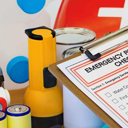 Individual filling out a checklist for an emergency kit