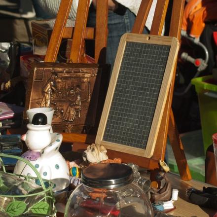 Flea market table with vintage items, including a blackboard and snowman ornament.