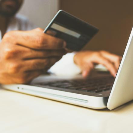 men holding his card in front of a computer