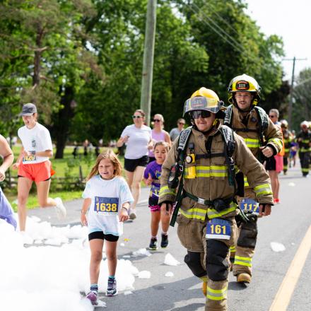 Kids and adults and firefighters running during a marathon