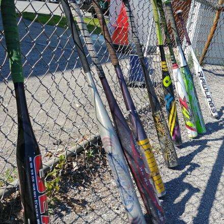 multiple baseball bat on a fence