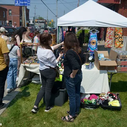 people looking at stuff for sell during a community yard sale.