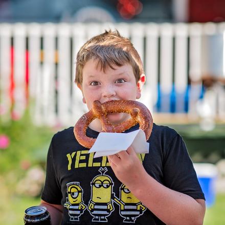 boy eating a pretzel on the street