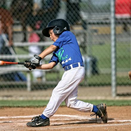 boy hitting a ball during a baseball game