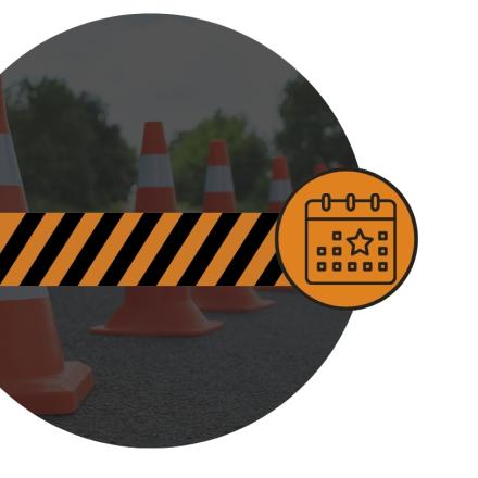 Circular graphic showing orange traffic cones with a black and orange road closure barrier in the foreground, overlaid with an orange calendar icon.