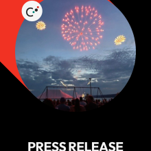 Fireworks light up the evening sky over a silhouetted crowd.