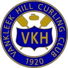 Blue and gold curling club crest with VKH on a shield, curling brooms, and a curling stone