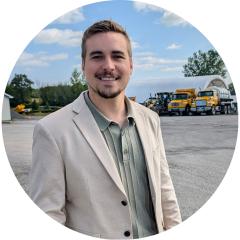 Young men Ryan Alexander in a suit in front of snow plows